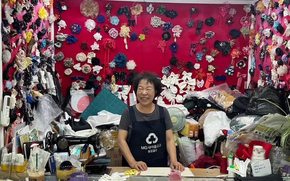 A merchant among handmade corsages at the Hwanhuisa workshop