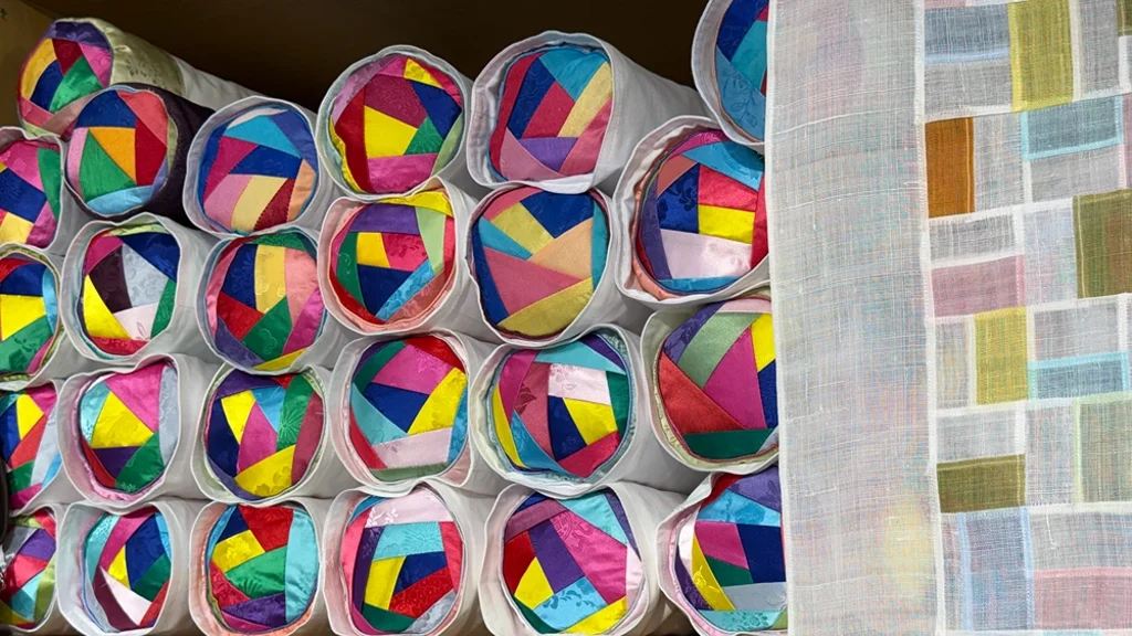 Colorful silk pouches and bojagi at a craft stall